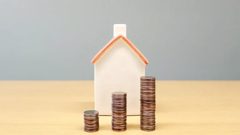 a house and stacks of coins on a table