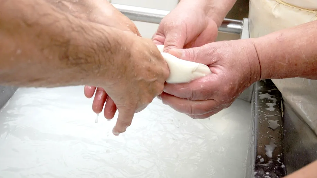 two people are washing their hands in a sink