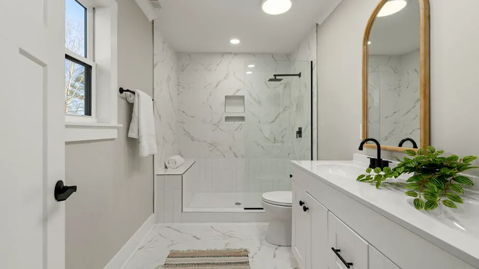 Bright modern bathroom featuring marble shower, large mirror, and sleek faucets.