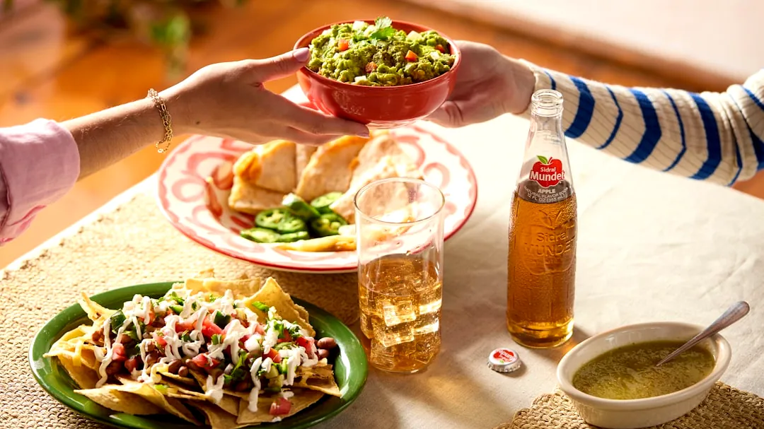 Friends sharing a meal with drinks and mexican food.