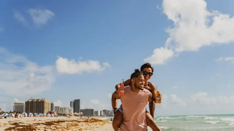 man and woman standing on beach during daytime